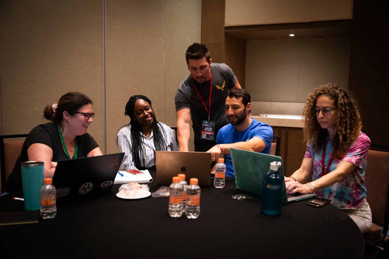 Diverse group engaged in a coaching roundtable discussion, collaborating and sharing insights in a professional setting.