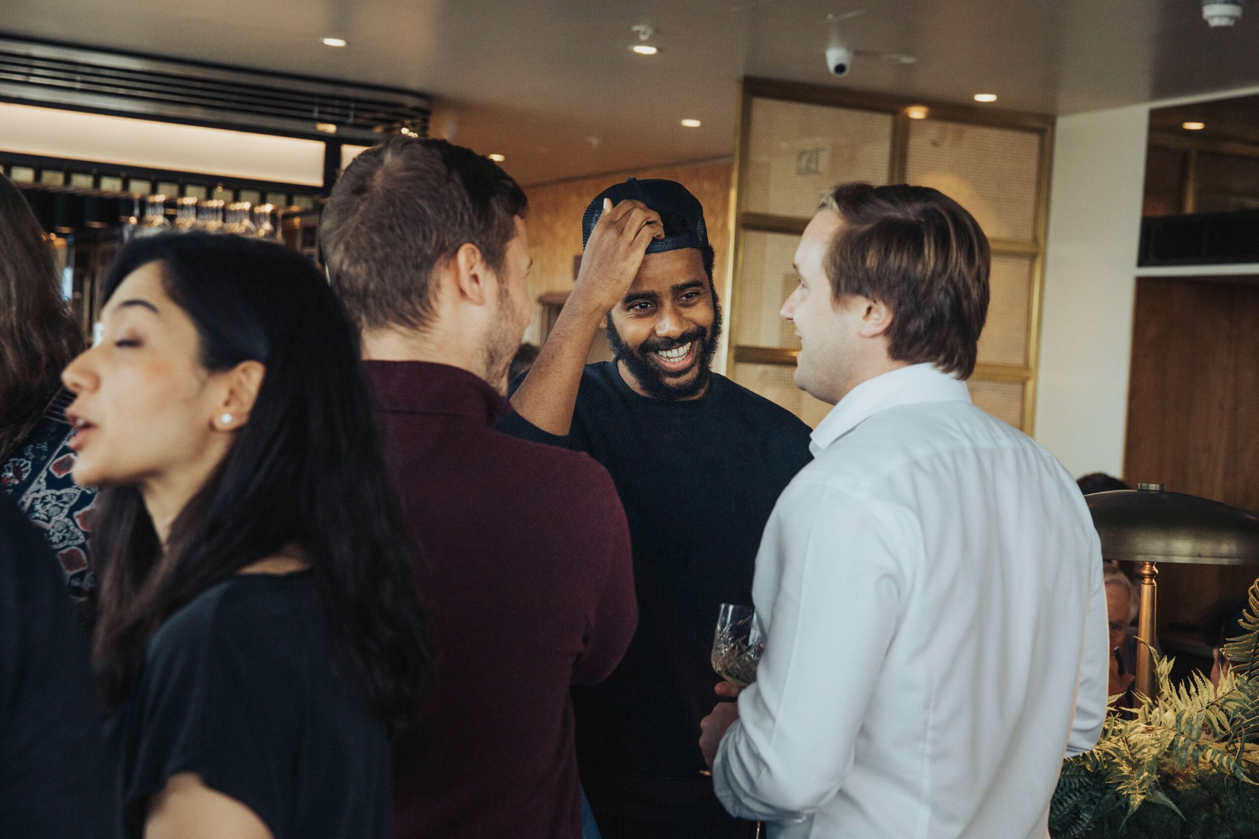 Group of professionals networking and smiling at the London Meetup event, August 2021, featured in a vibrant setting.